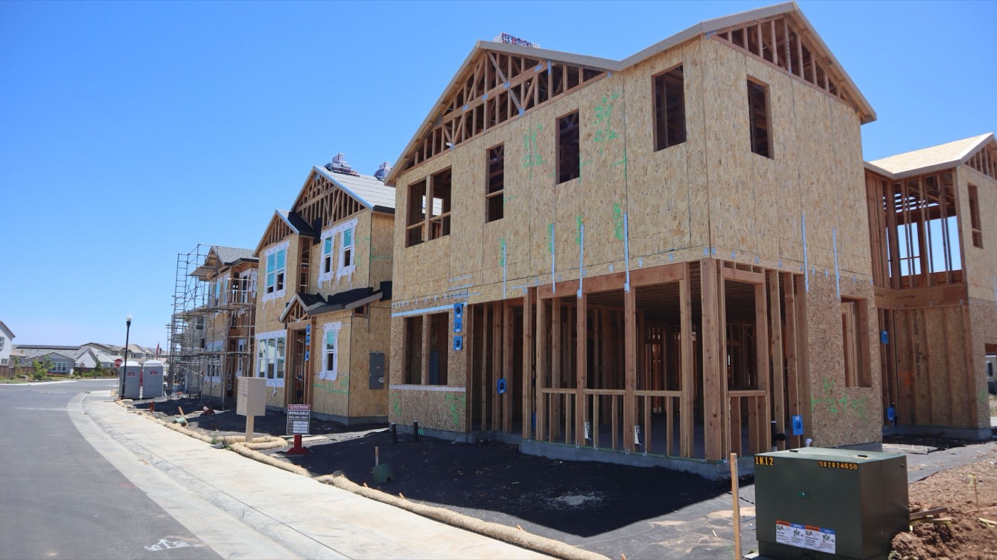 Row of new homes under construction along a residential street