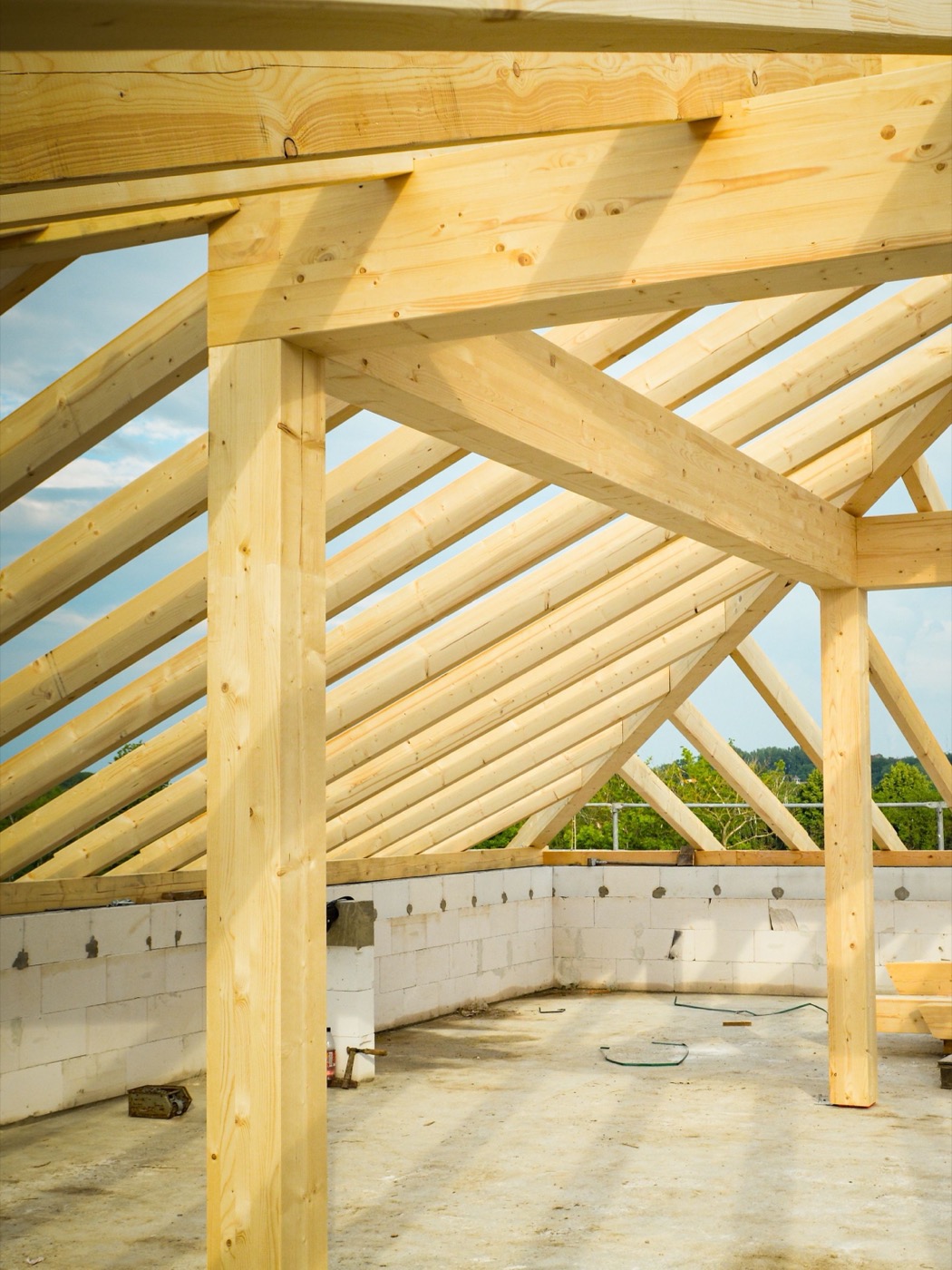 Wooden roof truss framing set against the sky